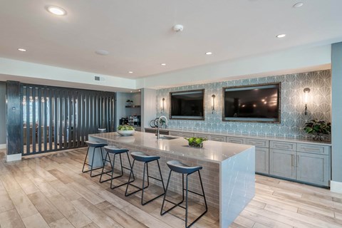 A kitchen with a bar area and stools.