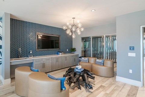 A modern living room with a blue and white patterned backsplash in the kitchen area.