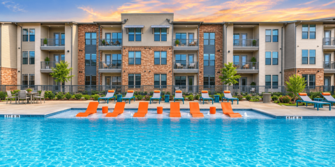 Resort-style swimming pool with in-water loungers and luxury apartment homes at One Preston Station in Celina, Texas.