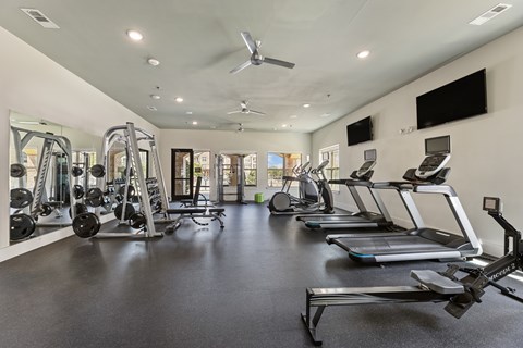 Fitness center with treadmills and ellipticals at Auberge of Burleson apartments in Burleson TX.