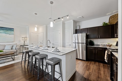 A kitchen with a white countertop and black bar stools.