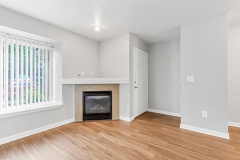 a living room with a fireplace and wooden floors