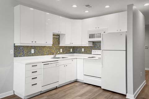 a white kitchen with white appliances and white cabinets