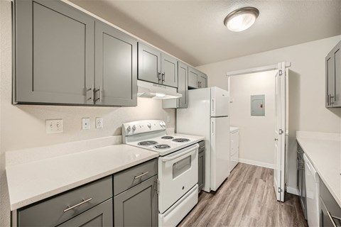 a kitchen with white appliances and gray cabinets
