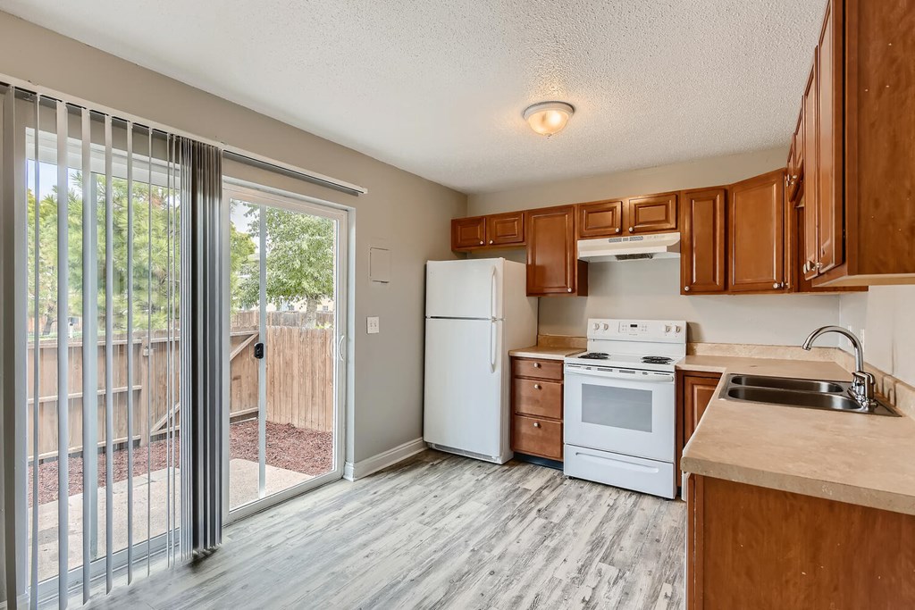 A kitchen with a Sliding Door, Refrigerator and Range oven at Alder Square Rental Townhomes