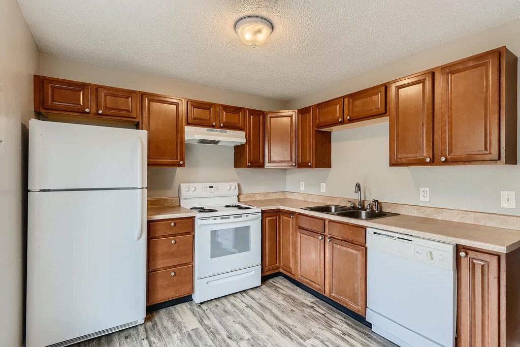 A kitchen with a refrigerator, range oven, dishwasher, and cabinets at Alder Square Rental Townhomes