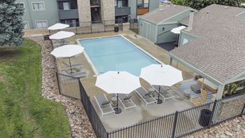 an aerial view of a resort style pool with umbrellas and lounge chairs at Hilltop View in Denver, CO