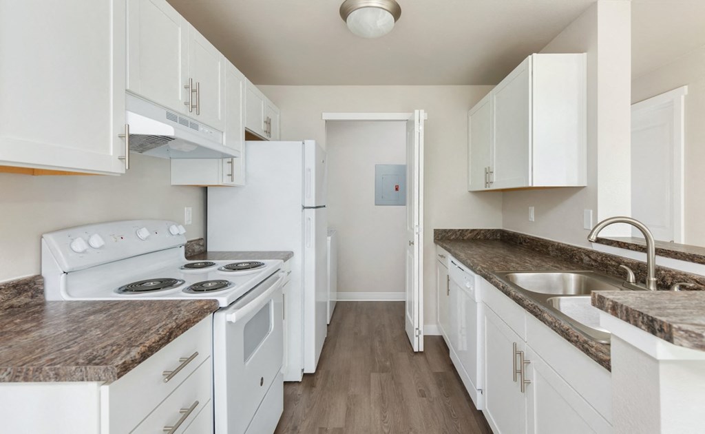 A kitchen with white appliances and cabinets.