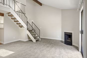 a living room with a staircase and a fireplace  at Hilltop View in Denver, CO