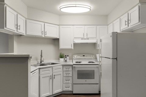 A kitchen with white cabinets and appliances.