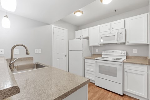 a kitchen with white appliances and a counter top