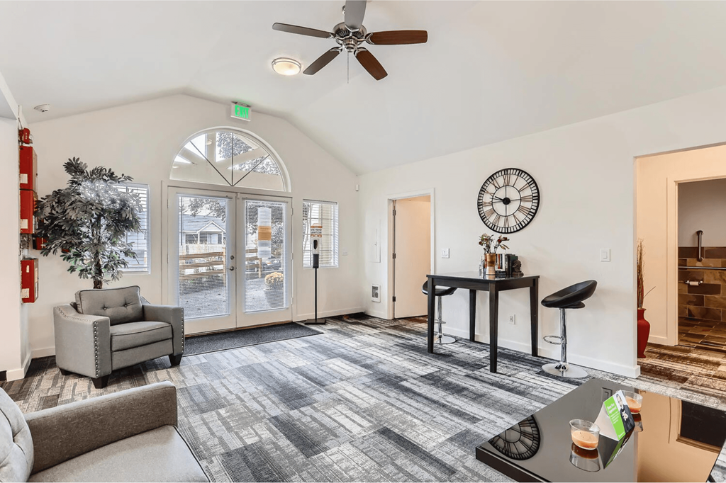 A living room with a grey couch, a black table, and a fireplace.