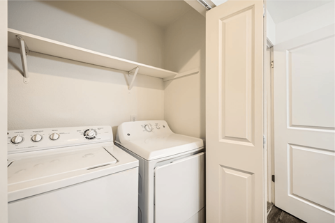 A small laundry room with a washer and dryer.