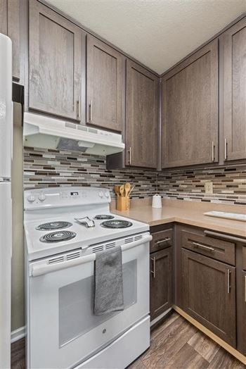 Renovated Kitchens featuring espresso cabinets, new electric range and elegant kitchen backsplashes at Chatsworth Pointe Apartments