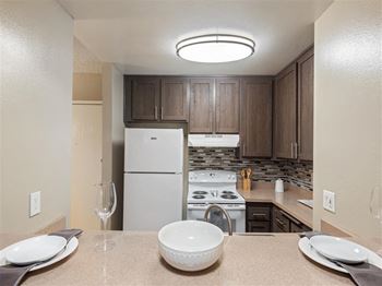 Renovated Kitchens featuring espresso cabinets, new electric range and elegant kitchen backsplashes at Chatsworth Pointe Apartments