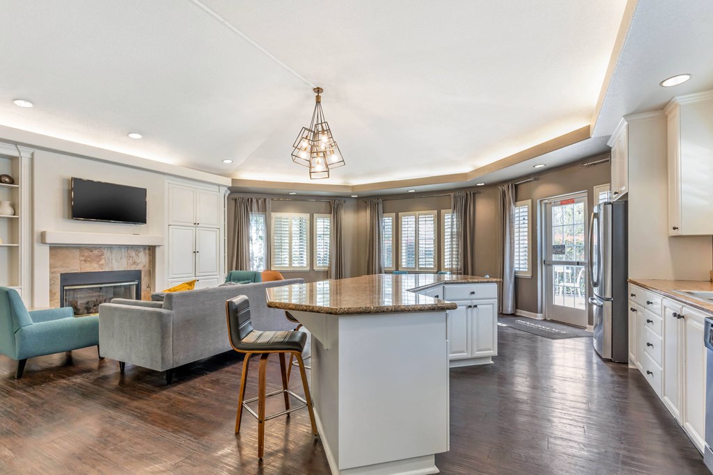 a kitchen with a center island and a living room with a fireplace