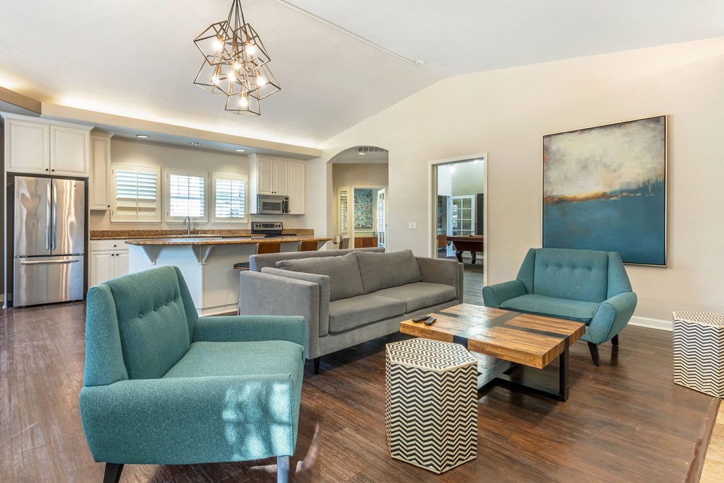 a living room with couches and chairs and a kitchen