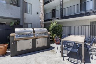 a patio with a grill and a table and chairs - Photo Gallery 3