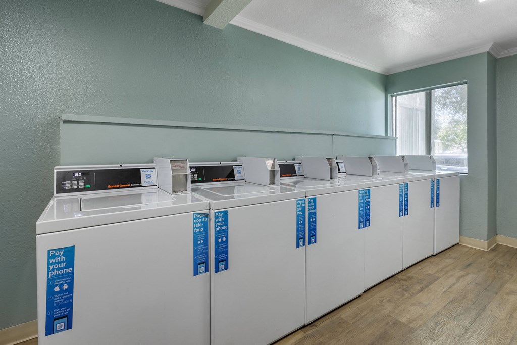 a row of washers and dryers in a room