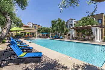 a swimming pool with blue and yellow lounge chairs at Trevi Apartment Homes, Chandler, AZ, 85224