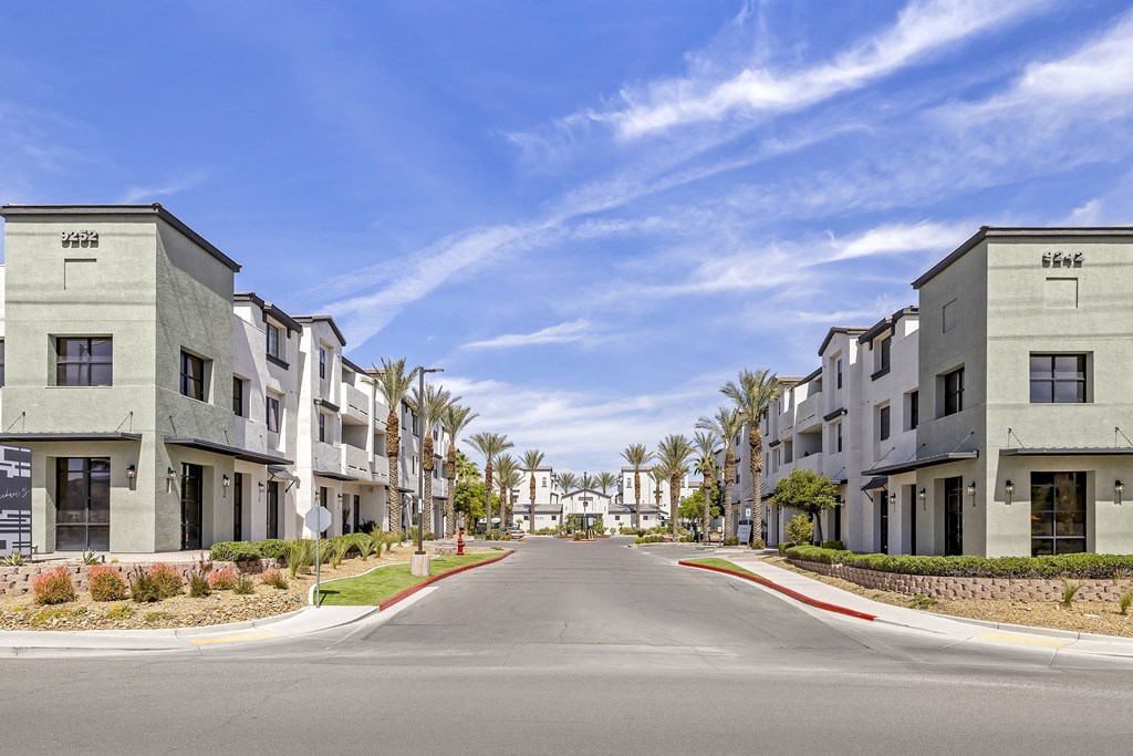 an empty street in an apartment complex with palm trees