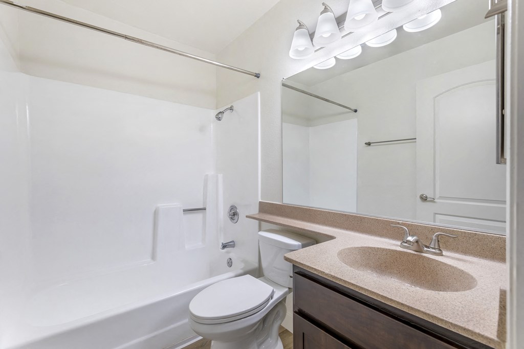 Step into luxury at Independence Plaza: where every bathroom is a retreat, complete with modern fixtures, a sleek sink, a cozy bath, and a mirror that reflects your impeccable taste.
