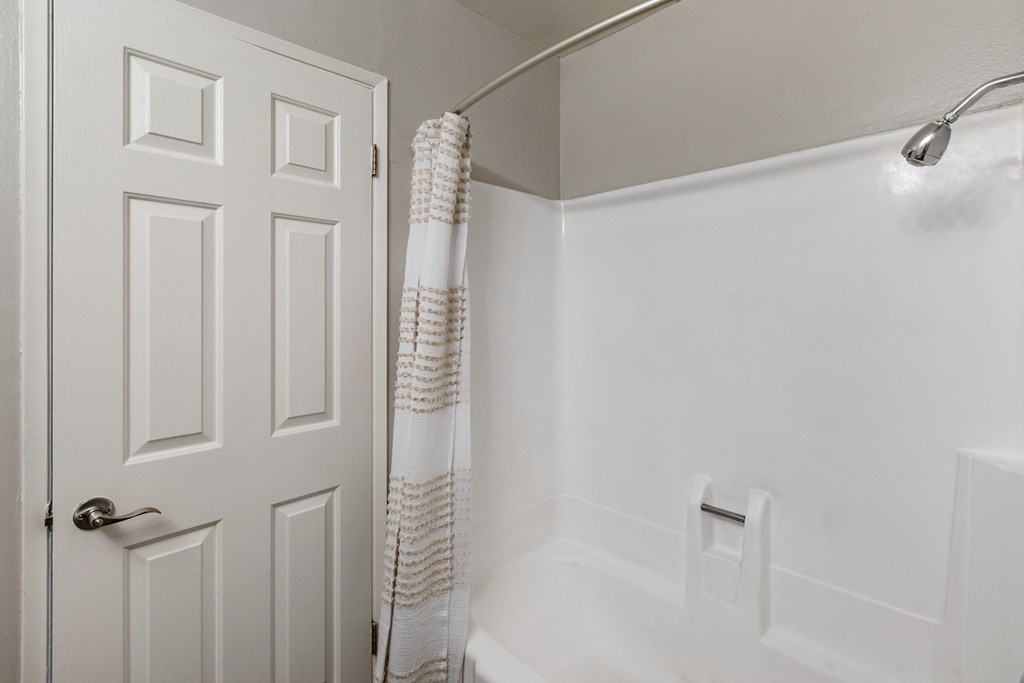 a bathroom with a white bathtub and a white door at Sage Creek Apartment Homes, California