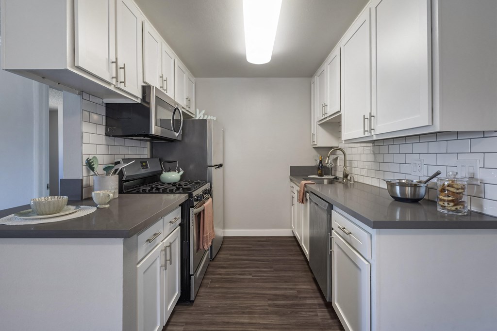 a kitchen with white cabinets and gray countertops at Sage Creek Apartment Homes, California, 93063