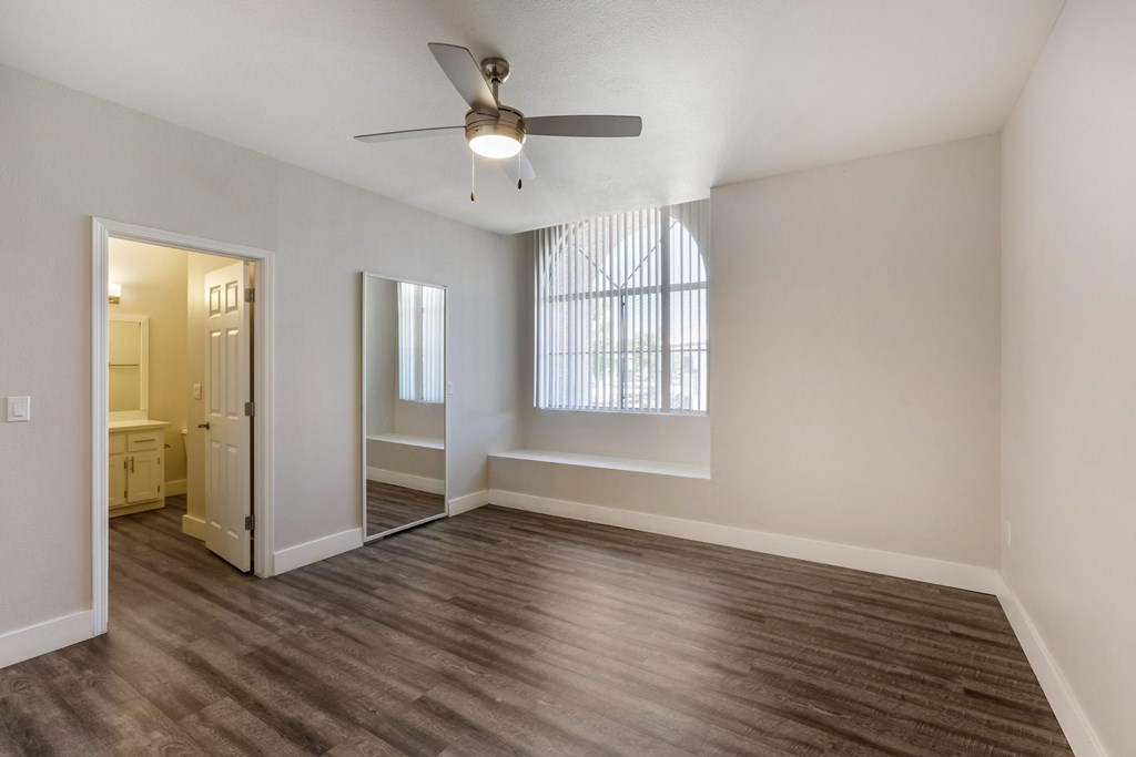 Step into our inviting bedroom, where a serene atmosphere is complemented by a soothing ceiling fan at Boulders at Lookout Mountain Apartment Homes, Arizona, 85022