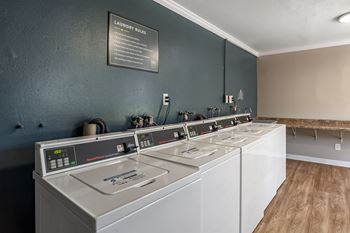 a row of washers and dryers in a laundry room