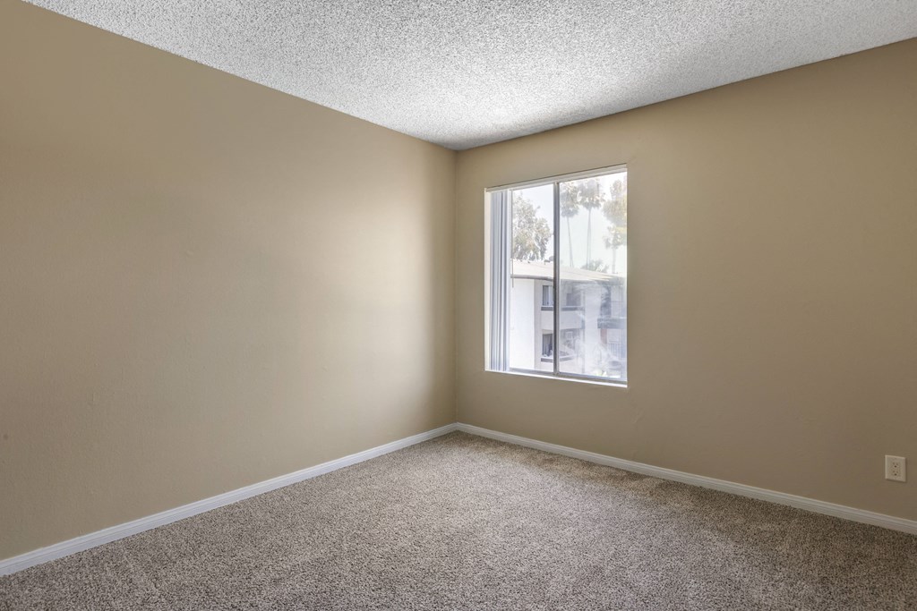 an empty bedroom with a large window