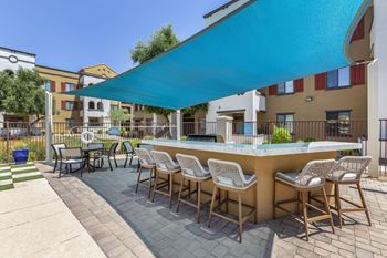 a patio with a bar and tables with chairs at Trevi Apartment Homes, Chandler, AZ, 85224