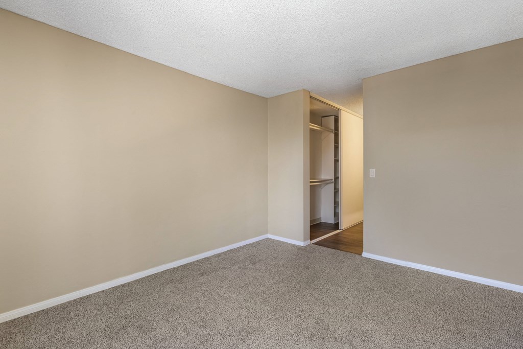 a bedroom with beige walls and a carpeted floor