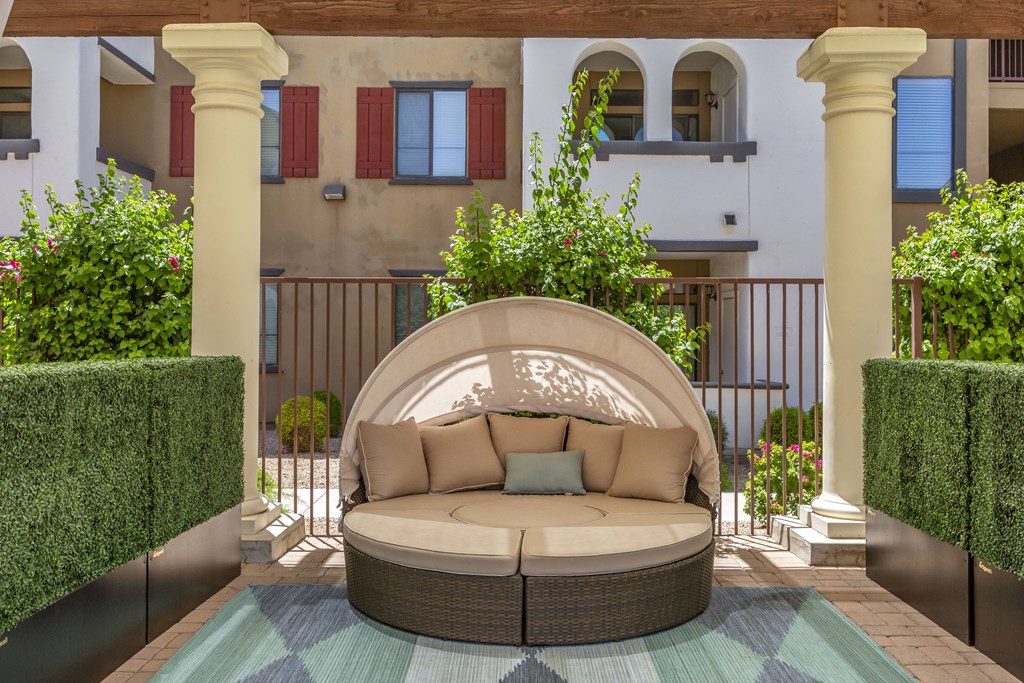 Enjoy our inviting patio, complete with a comfy couch and rug, perfect for unwinding outdoors at Trevi Apartment Homes, Chandler, AZ
