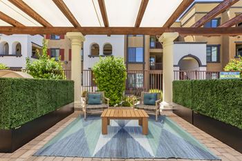 a patio with a table and chairs and a pool at Trevi Apartment Homes, Chandler, 85224