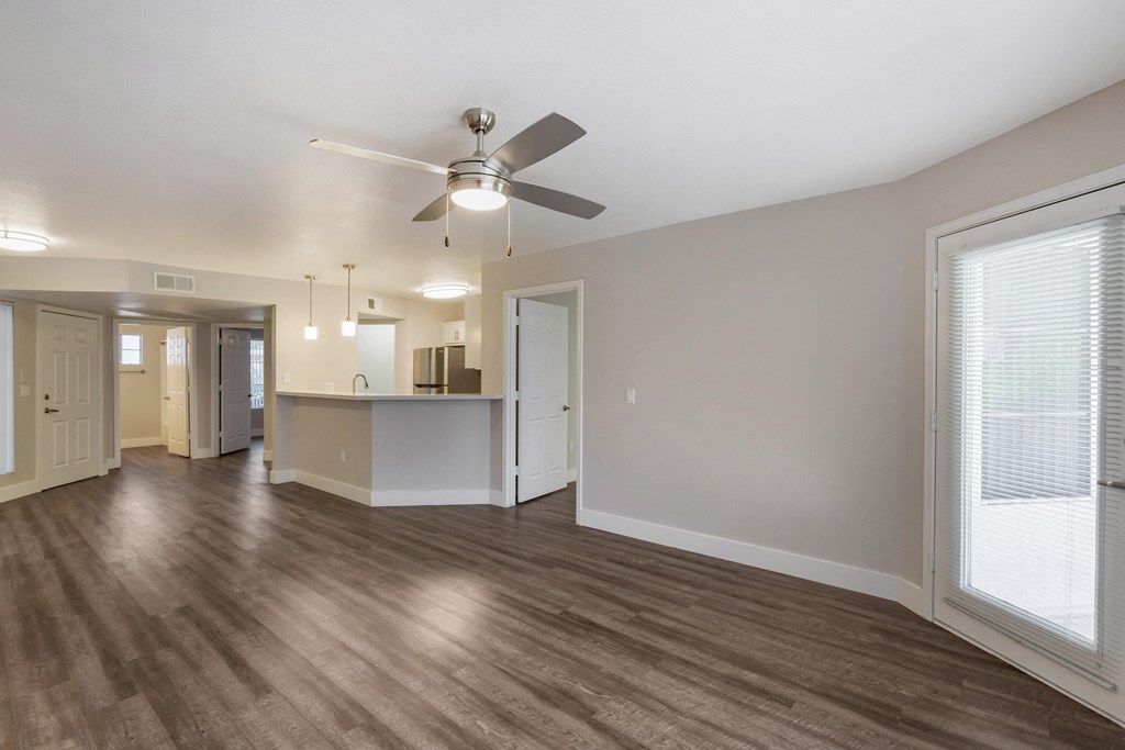 Step into our inviting living room adorned with sleek hardwood floors and complemented by a gentle ceiling fan breeze at Boulders at Lookout Mountain Apartment Homes, Phoenix, 85022
