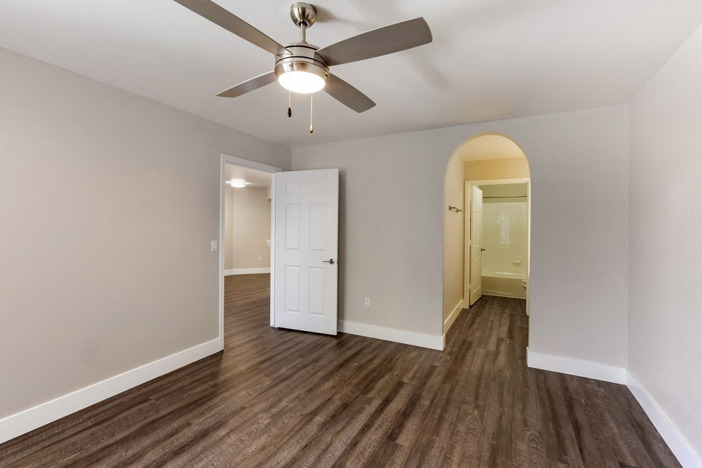 Indulge in the allure of hardwood floors and the gentle breeze of a ceiling fan in our cozy bedroom at Boulders at Lookout Mountain Apartment Homes, Phoenix, AZ 85022