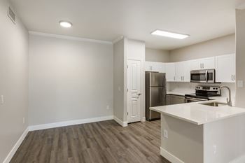 an empty kitchen with white cabinets and a stainless steel refrigerator at Trevi Apartment Homes, Chandler, Arizona