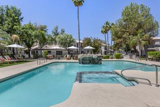 a large swimming pool with a fountain and palm trees in the background - Photo Gallery 4