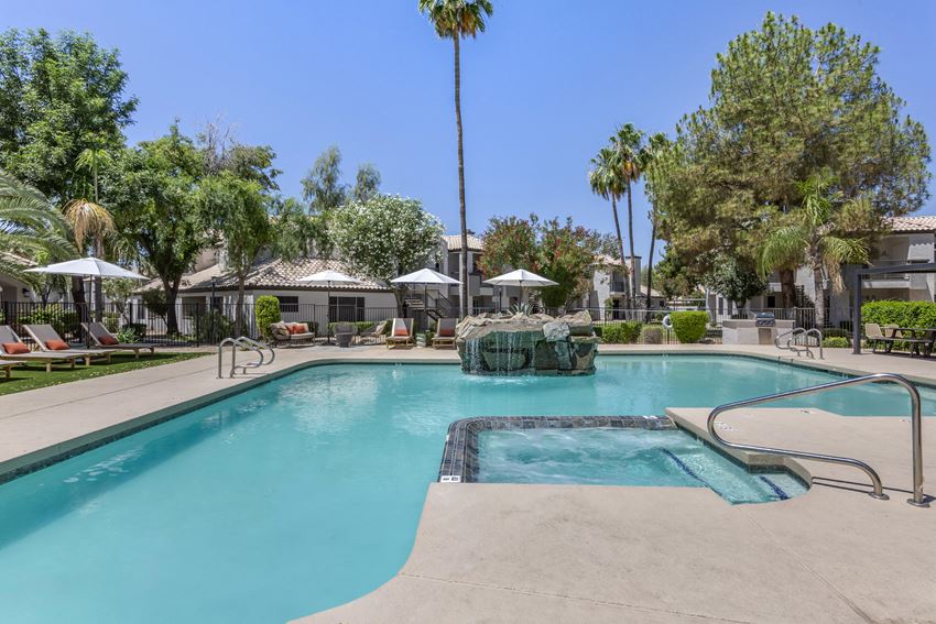 a large swimming pool with a fountain and palm trees in the background - Photo Gallery