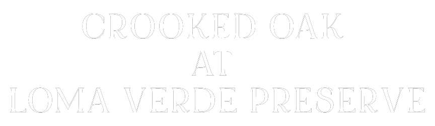 A green sign with white text that reads "Crooked Oak at Loma Verde Preserve".