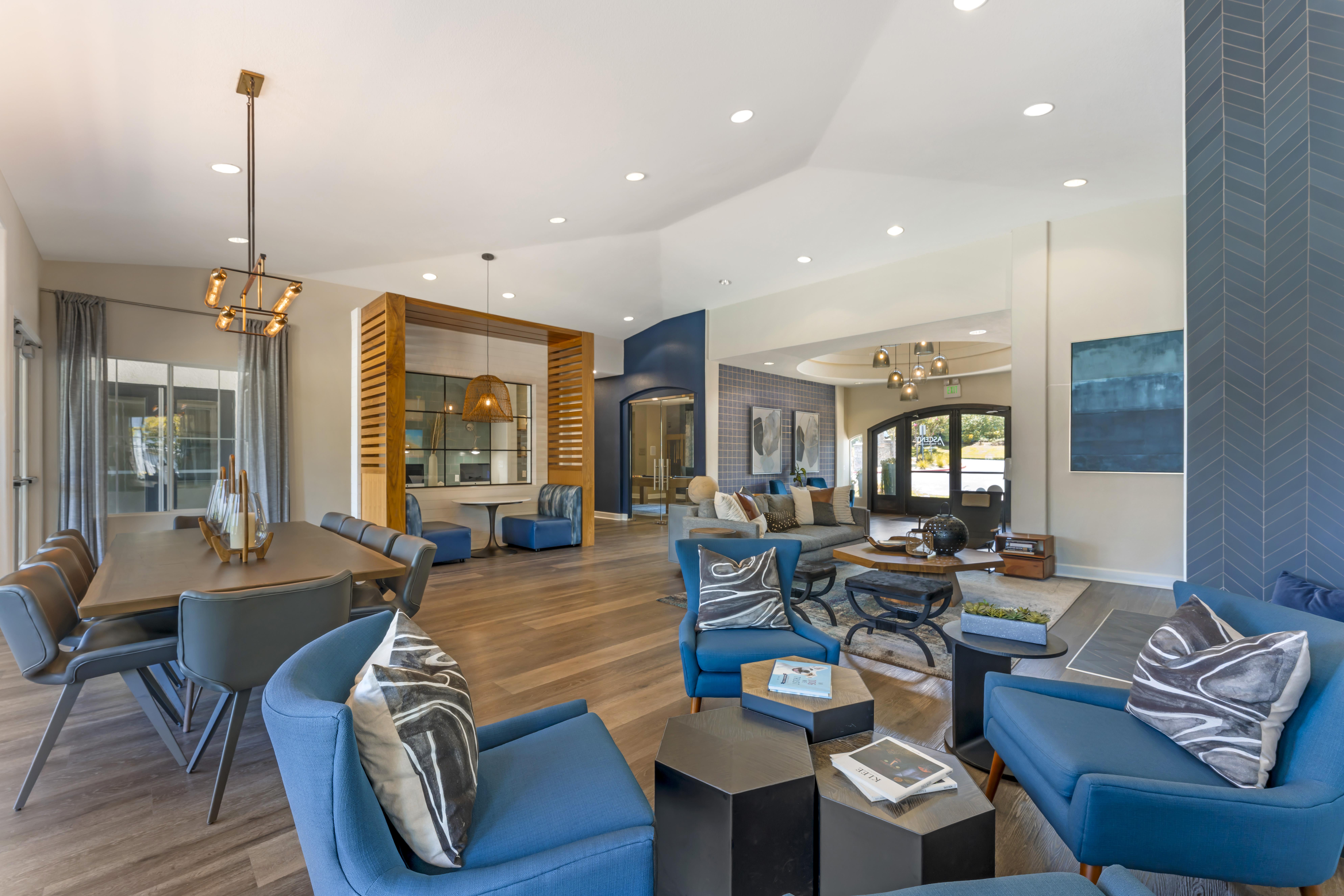 A modern living room with blue chairs and a wooden coffee table.