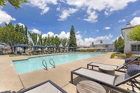 Dive into pure relaxation at Ascent at the Galleria’s pool deck in Rosevilla, CA—adorable cabanas and plush lounge chairs surround a sparkling pool, offering serene and stylish outdoor lounging vibes.