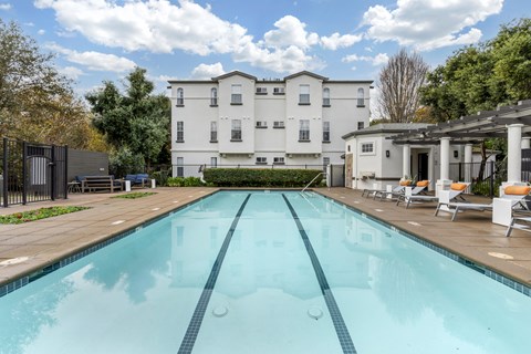 A large white building with a pool in front.