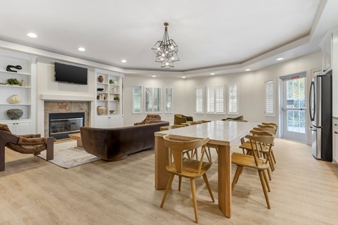 A modern living room with a fireplace and a dining table set up.