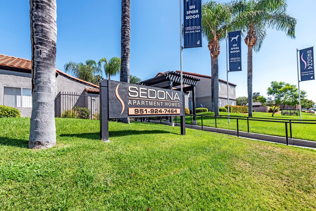 Sedona Apartments in Moreno Valley welcomes you with a modern, inviting entrance framed by lush landscaping and stylish, well-lit pathways.