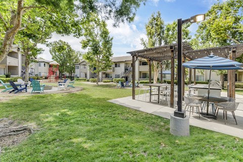 A sunny day at the park with a gazebo and picnic tables.