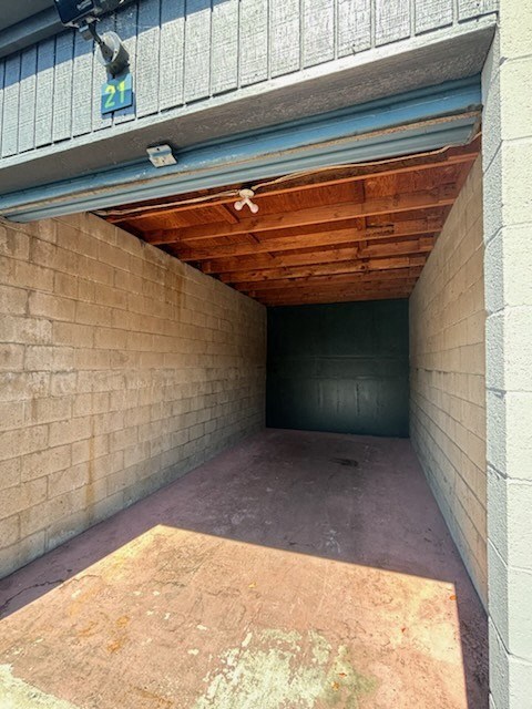 an empty garage with a brick wall and wood ceiling