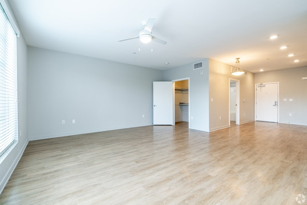 A spacious room with a ceiling fan and lighting fixtures.