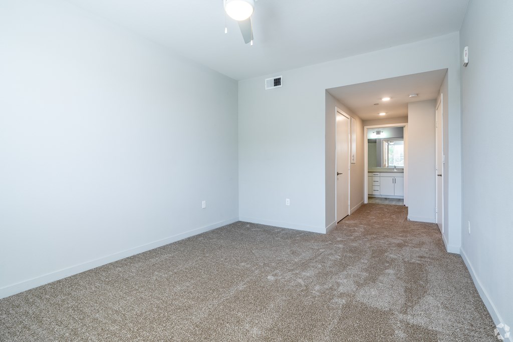 A long hallway with carpeted floors and white walls.